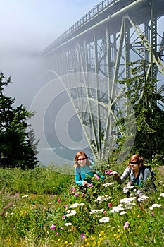 Happy friends hiking by ocean in foggy morning.