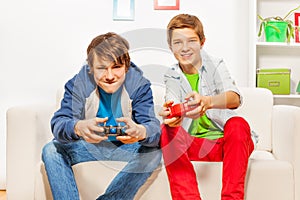 Happy friends hold joysticks and play game console