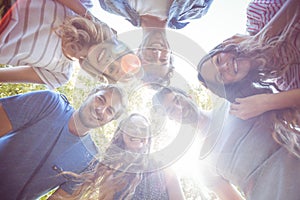 Happy friends huddling in circle in the park