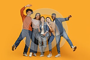 Happy friends hugging and smiling on orange background