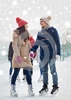 Happy friends ice skating on rink outdoors