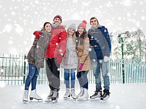 Happy friends ice skating on rink outdoors