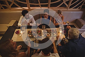 Happy friends interacting with each other while having dinner