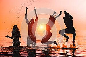 Happy friends jumping inside water on tropical beach at sunset - Group of young people having fun on summer vacation - Youth