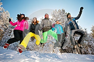 Happy friends jumping in the snow