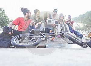 Happy friends listening music in city park - Breaker,skaters and freestyle bikers having fun together - Concept of diverse culture