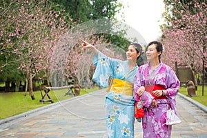 Happy friends looking at view of sakura park