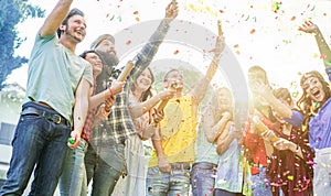 Happy friends making party,throwing confetti and using colorful smoke bombs at party outdoor - Young people having fun together -