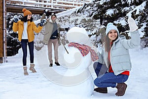 Happy friends making snowman. Winter vacation