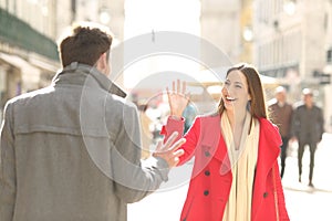 Happy friends meeting and greeting in the street photo