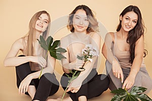 Happy friends multicultural women with natural green leaf, blond model girl with clear skin face. Concept Fashion flora