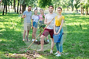 happy friends planting new trees and volunteering