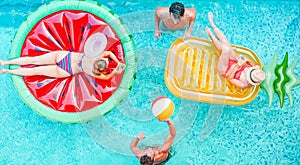 Happy friends playing with air lilo ball inside swimming pool - Young people having fun on summer holidays vacation - Travel,