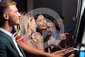 Happy Friends Playing Arcade Machine in a Casino