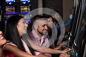 Happy Friends Playing Arcade Machine in a Casino