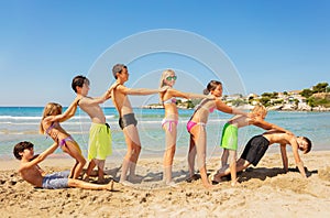 Happy friends playing beach games in summer