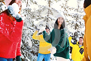 Happy friends playing snowballs. Winter vacation