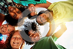 Happy, friends and portrait of children huddle for bonding, playing and fun together outdoors. Diversity, youth and low