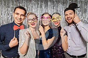 Happy friends posing with party props