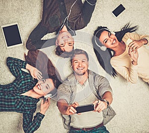 Happy friends relaxing with gadgets