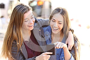 Happy friends sharing a smart phone