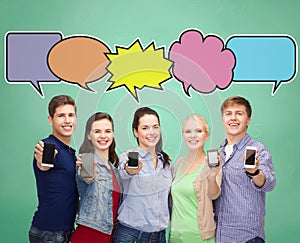 Happy friends showing blank smartphones screens