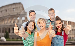 Happy friends showing thumbs up over coliseum