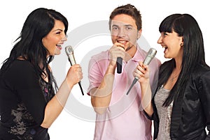 Happy friends singing at karaoke party photo