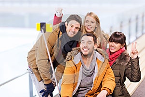 Happy friends with smartphone on skating rink