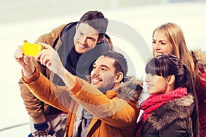 Happy friends with smartphone on skating rink