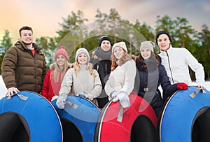 Happy friends with snow tubes outdoors in winter