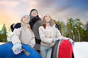 Happy friends with snow tubes outdoors in winter