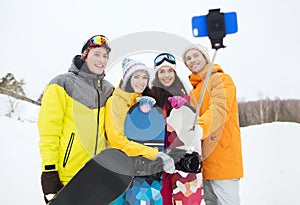 Happy friends with snowboards and smartphone