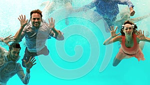Happy friends swimming underwater