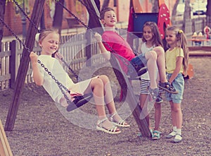 Happy friends swinging on swing