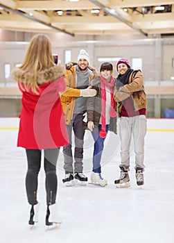 Happy friends taking photo on skating rink