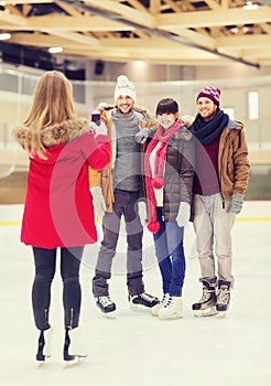 Happy friends taking photo on skating rink