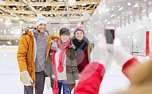 Happy friends taking photo on skating rink