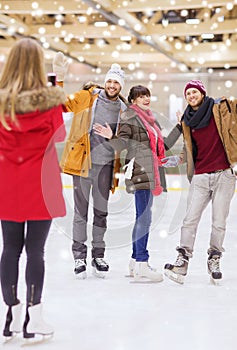 Happy friends taking photo on skating rink
