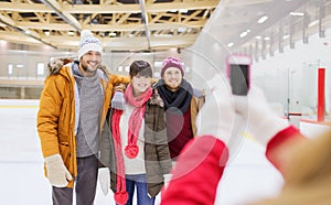 Happy friends taking photo on skating rink