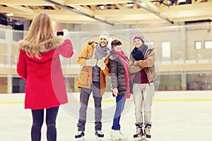 Happy friends taking photo on skating rink