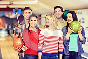 Happy friends taking selfie in bowling club