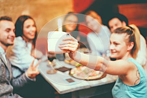 Happy friends taking selfie with instant camera in trendy cocktail bar restaurant - Young people having fun having appetizer