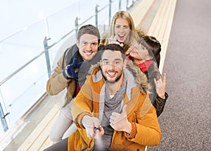 Happy friends taking selfie on skating rink