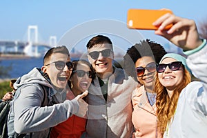 Happy friends taking selfie with smartphone