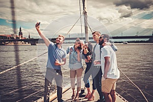 Happy friends taking selfie on a yacht