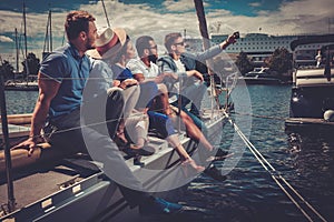 Happy friends taking selfie on a yacht