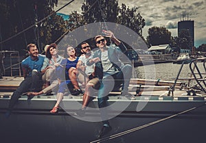 Happy friends taking selfie on a yacht