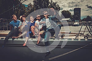 Happy friends taking selfie on a yacht