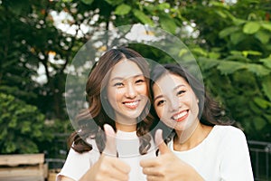 Happy friends or teenage girls having fun outdoors